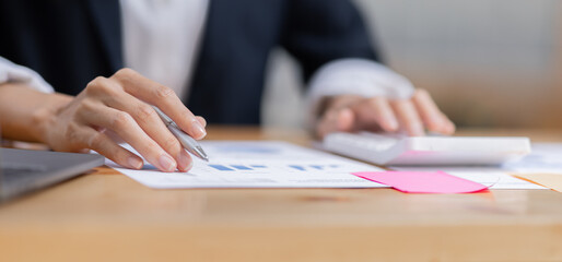 Cheerful female businesswoman entrepreneur professional working on laptop while sitting in workplace office desk, business asian woman do Documents, tax, report analysis Savings, finances economy.