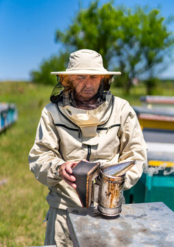 Farmer In Bee Costume Workiing With Beehives. Beekeeper Man In Protective Costume.