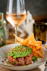 Tuna Poke with Wonton Crackers topped with Avocado and a glass of Rose