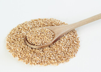 Steel cut oats and wooden spoon on white