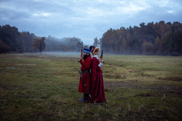 Duel of a man and a woman in 17th century costumes using antique pistols. Enemies stand back to...