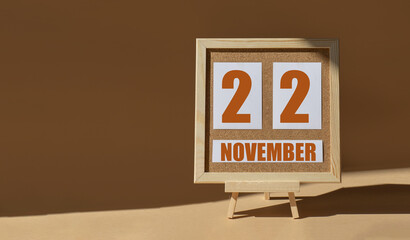 November 22th. Day 22 of month, Calendar date. Cork board, easel in sunlight on desktop. Close-up, brown background.  Autumn month, day of year concept
