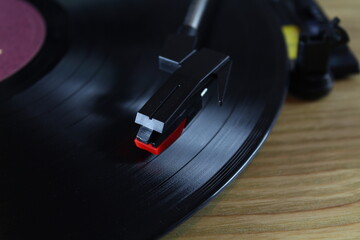 close up vintage vinyl record player playing music from LP album. Vintage wooden vinyl player. Analog music concept. selective focus and underexposed planning