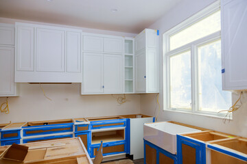 Installation of white kitchen cabinets furniture interior with newly constructed house
