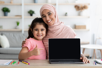 Website Mockup. Little Girl And Her Islamic Mom Pointing At Blank Laptop