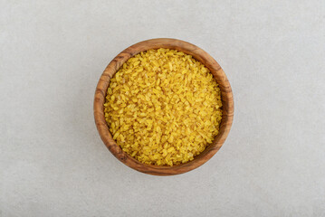 Dried bulgur in wooden bowl