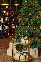 Christmas home room with fir tree and festive bokeh lighting, blurred holiday background, gift boxes and new year decor. Soft selective focus.