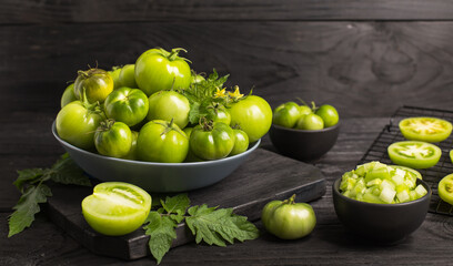 Fresh, organic green tomatoes on the dark wooden table