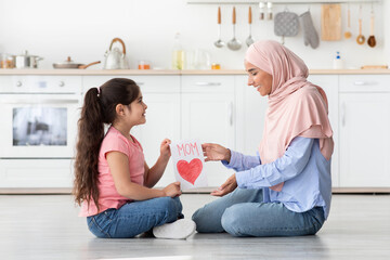 Surprise For Mom. Girl Giving Greeting Card To Muslim Mommy At Home