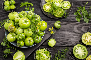 Fresh, organic green tomatoes on the dark wooden table