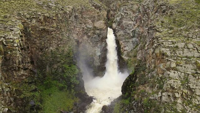 Aerial: A powerful stream of water falls from a height at Kurkure waterfall