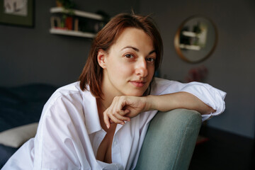 A woman is sitting in a home office and resting. Portrait