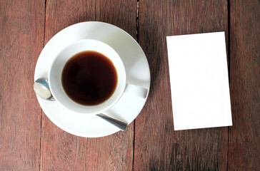 cup of coffee on wooden table with blank card