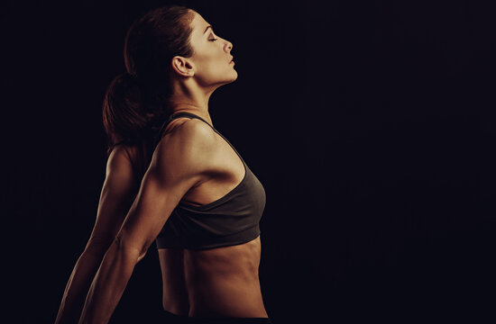 Strong Sporty Woman Doing The Arms And Shoulders Stretching Exercise Holding The Hands In Fist Behind The Back To Relaxing In Sport Wear. Sports Exercising. Closeup. Concept