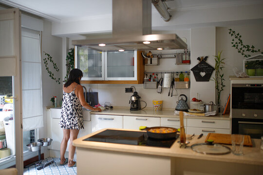 Anonymous brunette in kitchen at home