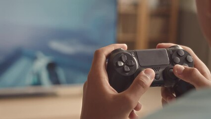 Close up of unrecognizable gamer pressing buttons on controller fast while playing fps video game at home - Powered by Adobe