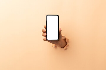 man hand holding a blank screen smart phone on a brown background.