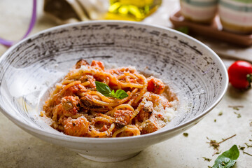Pasta spaghetti with seafood, tomato sauce and parmesan on stone table, macro close up