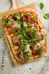 Pinsa with parma ham and mushrooms, rome pizza, top view vertical
