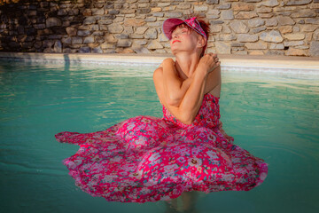 Femme se baignant avec sa robe dans la piscine
