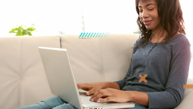 Animation of shapes over biracial woman using laptop