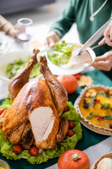 Cropped view of thanksgiving turkey near blurred family and dinner at home