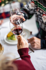 partial view of blurred man clinking wine glasses with daughter during thanksgiving dinner