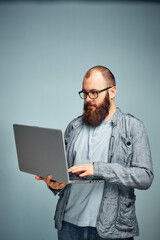 lifestyle successful freelancer man with beard achieves new goal with laptop in loft interior.