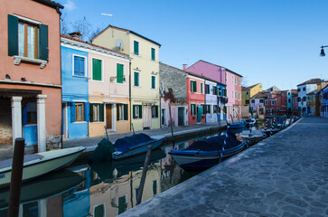 Obraz na płótnie Canvas Barche ormeggiate in un canale di Burano con le tipiche case colorate in una giornata di sole 