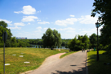 Fototapeta na wymiar Pavement in green city park with river