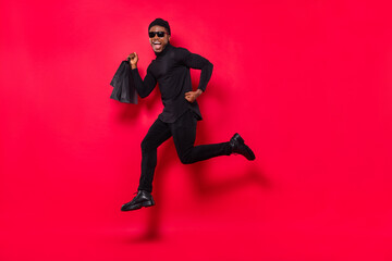 Fototapeta na wymiar Full length body size view of handsome trendy cheerful guy jumping running shopping isolated over bright red color background
