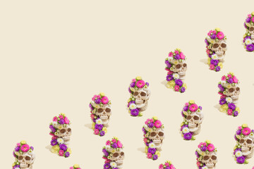 Creative seamless pattern made of realistic human skulls with colorful flowers on pastel beige background. Aesthetic Mexican Day of the Dead (Dia De Los Muertos) or Halloween concept.