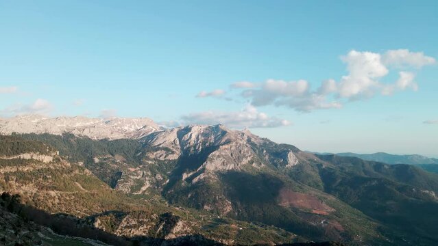 Beautiful panoramic view of mountain peaks with clouds on a sunny day, 4k