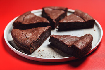 Chocolate Flourless Cake on red background. Soft chocolate gÃ¢teau or Brownie cake. Selective focus - 536136392