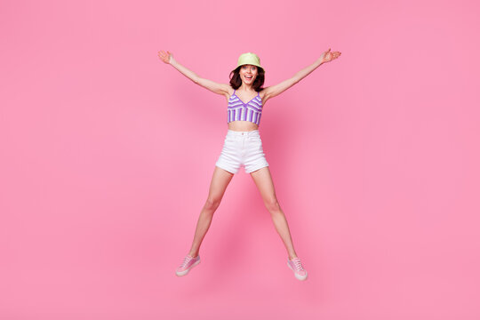 Full length photo of pretty adorable girl dressed violet top jumping high like star isolated pink color background