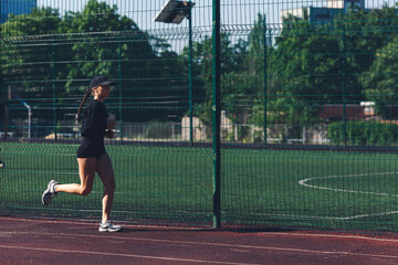 Morning run at the stadium. The girl with the phone goes in for sports.