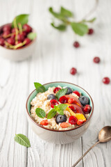 Oatmeal cereal with berries in a bowl on the table. A healthy breakfast. Baby food.