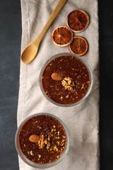 Bowl of homemade chocolate chia pudding, made with dark chocolate, chia seeds, orange juice and plant based milk. Top view.
