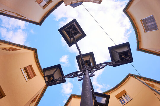 Iron street lamp with several lights in a circular square with blue sky