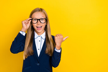 Photo of astonished girl arm touch spectacles direct show demonstrate offer proposition empty space isolated on yellow color background