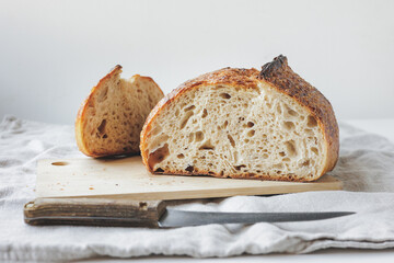 Round fresh bread lies on the cutting board. Baking and confectionery in a bakery or restaurant....