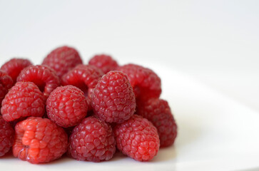 Fresh red raspberries on a white background