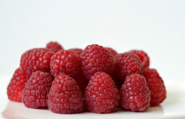 Fresh red raspberries on a white background