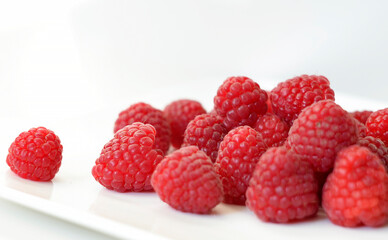 Fresh red raspberries on a white background