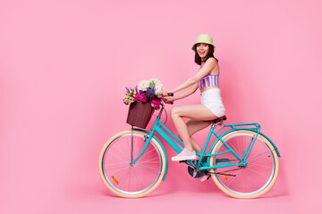 Full length photo of funny charming lady wear purple bra riding bicycle empty space isolated pink color background