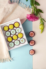 traditional brigadeiros, nest milk, passion fruit, Sicilian lemon, present, flowers, blue table background, benge, white, flowers