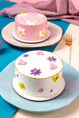 colorful bento cake, blue and pink table, colorful sprinkles and flowers