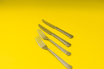 Cutlery lying on a yellow background, minimalism