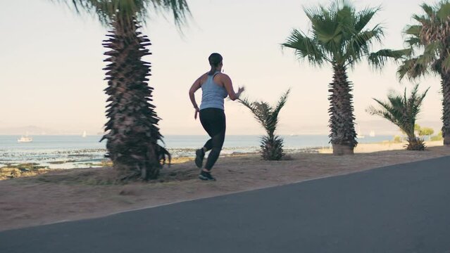 Running, fitness and overweight woman on beach street for wellness and healthy lifestyle with energy, speed and motivation. Sports, runner person exercise, training or workout run on a road by ocean