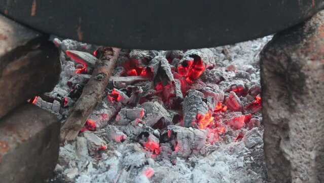Tomatoes boiled in a cauldron on a hot fire turn into tomato paste.